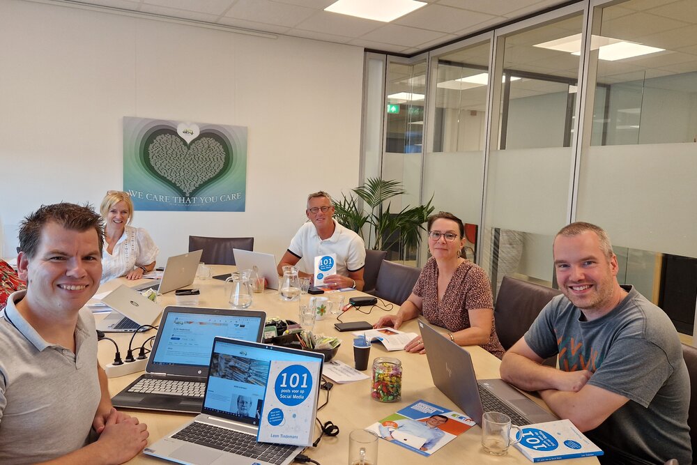 LinkedIn in-company training bij een klant op kantoor: een team werkt samen aan hun LinkedIn-profielen